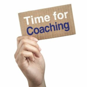 Main qui tient un carton avec le texte "time for coaching"